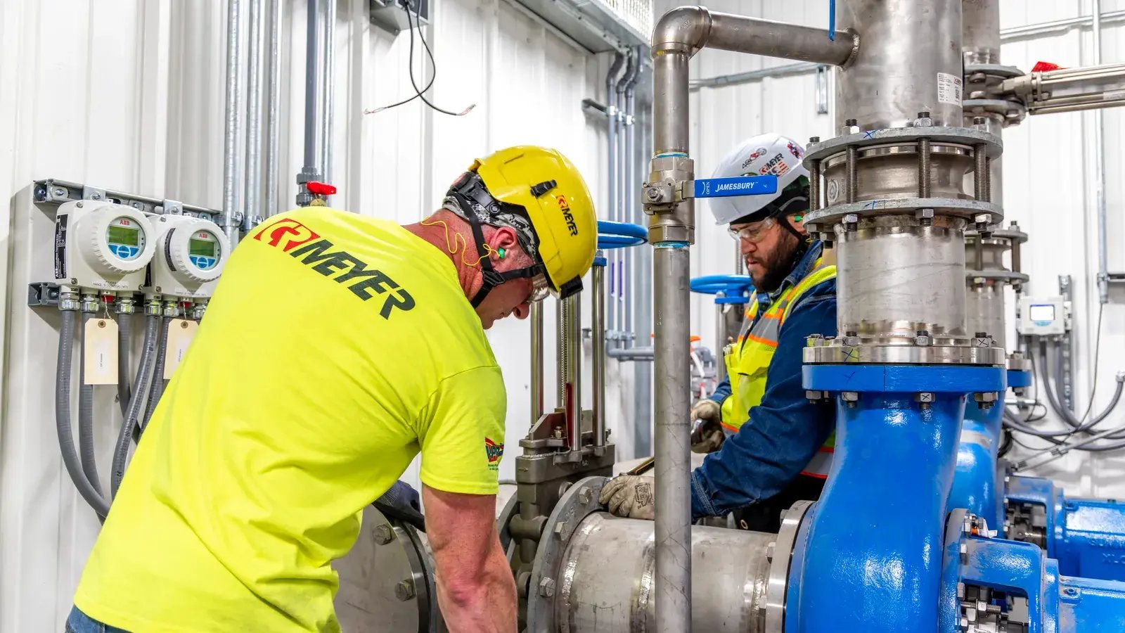 industrial workers maintaining pipe system