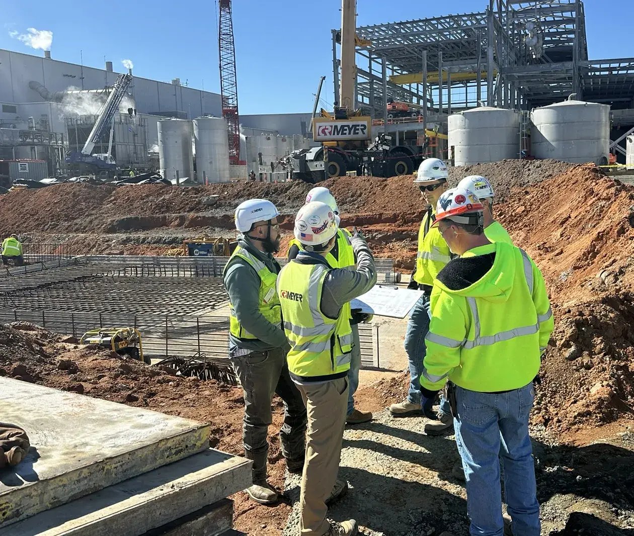 construction workers meeting industrial site